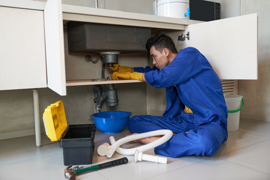 asian-plumber-blue-overalls-clearing-blockage-drain_1098-17773